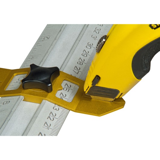 STANLEY STHT1-05933 utility knife making a precise cut along a metal measuring ruler, close-up angle.