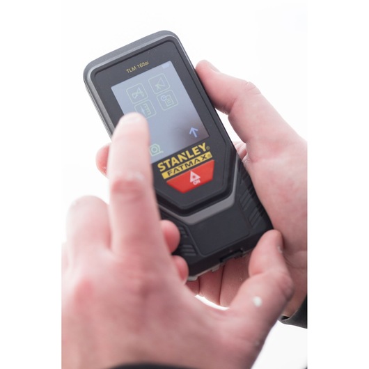 Photo of STANLEY STHT1-77142 laser distance measurer in use, user interacting with touch screen.