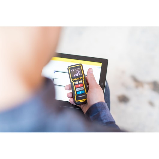 STANLEY STHT1-77343 digital laser measurer in hand, screen displaying measurement, photography product.