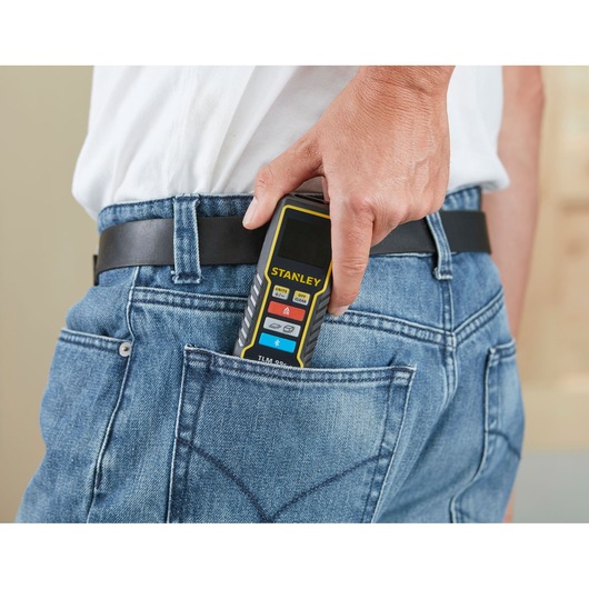 Stanley STHT1-77343 laser distance meter in back pocket of blue jeans, portable photography angle.