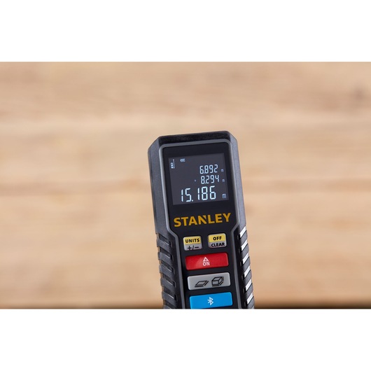 Photo of STANLEY STHT1-77361 laser distance measurer handheld device, front view, with display and control buttons.
