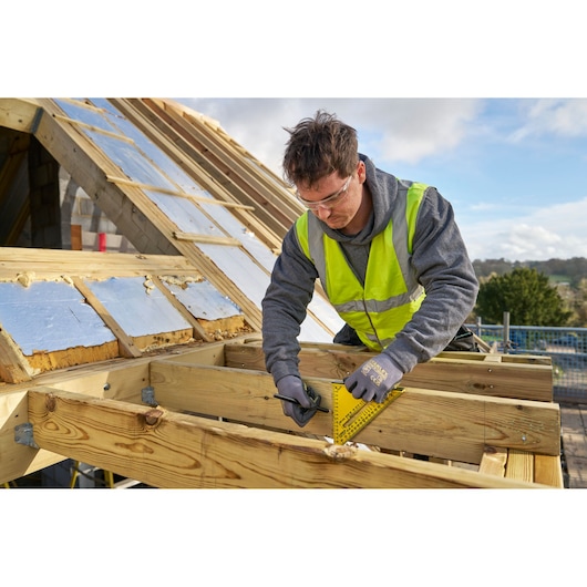 Photo of a worker using a STANLEY STHT46012-0 rafter square on timber at a construction site.