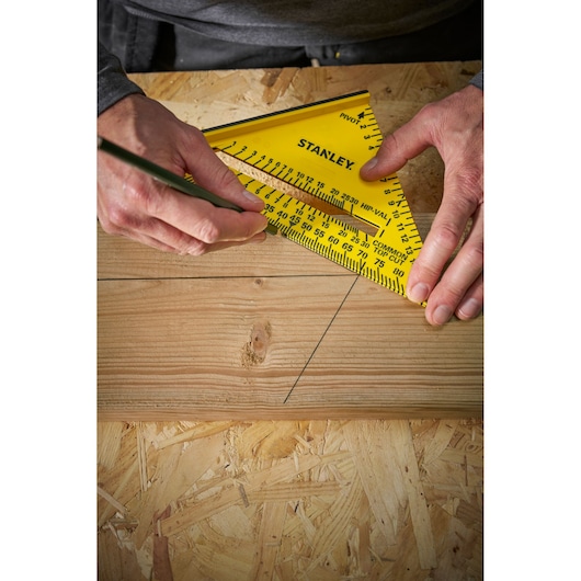 STANLEY STHT46012-0 yellow triangular carpenter's square used to mark wood, top view, photography.