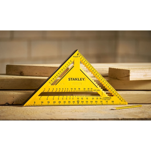 STANLEY STHT46013-0 yellow triangular carpenter square on wood planks, product category photography.