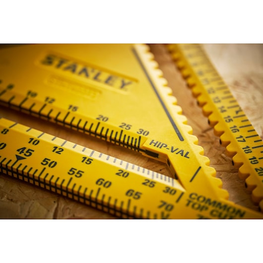 Photo of STANLEY STHT46013-0 yellow plastic measuring triangle with engraved black markings, angled view.