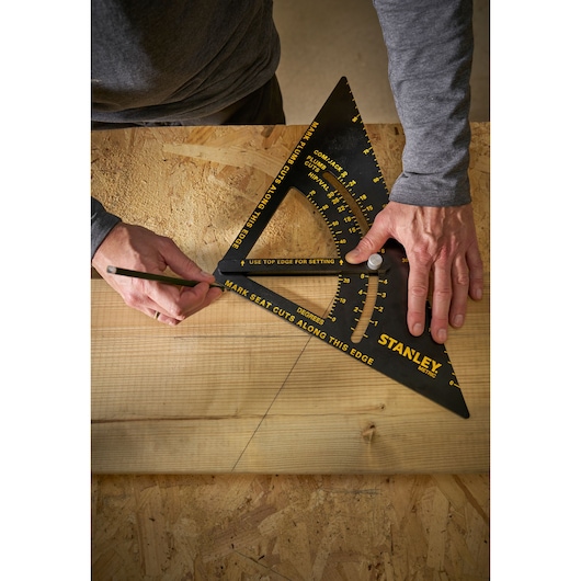 Photo of STANLEY STHT46054-0 metric carpenter square in use drawing lines on wooden board.
