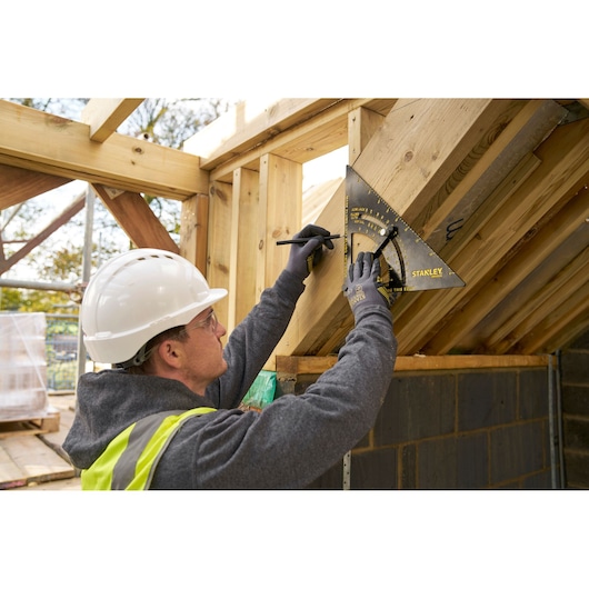 STANLEY STHT46055-0 rafter square used to mark wood angles at a construction site.