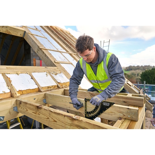 STANLEY STHT46055-0 roofing square used on wood frame during roof construction outdoors.