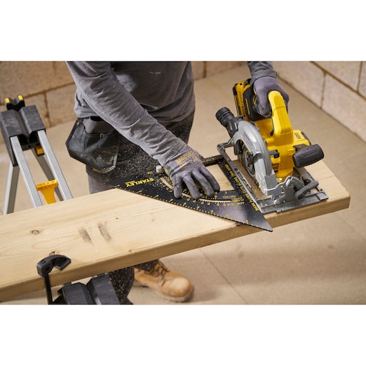 STANLEY STHT46055-0 carpenter's square being used to guide a circular saw on a wooden board, workshop setting.