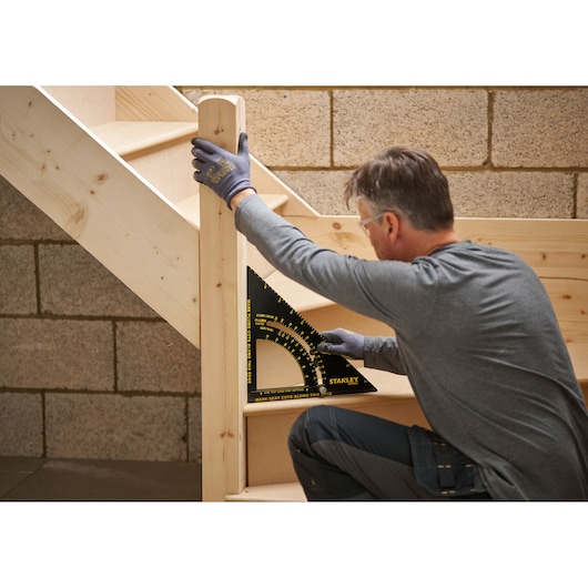 STANLEY STHT46055-0 square tool used to measure and mark wooden stairs during construction.