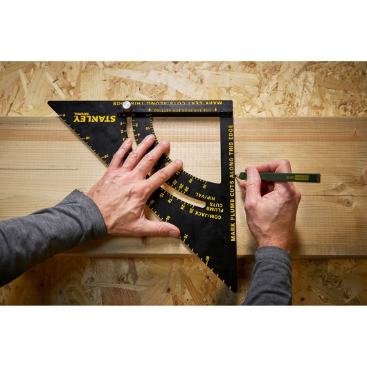 STANLEY STHT46055-0 photography of black and yellow carpenter square tool in use on wooden board, top view.