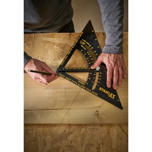 Stanley STHT46055-0 photography of black triangular rafter square used to mark a wooden board.