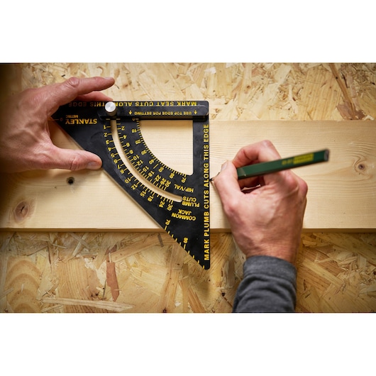 STANLEY STHT46056-0 photography of a black marking square tool with yellow text, held on a wooden board.