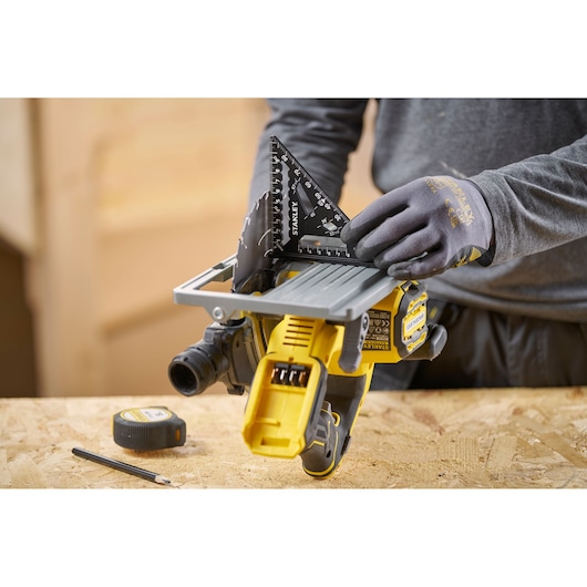 STANLEY STHT46100-0 black carpenter's square held by gloved hand on a workbench, photo shows top angle.