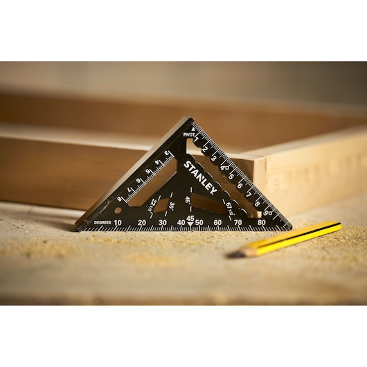 STANLEY STHT46100-0 black triangular carpenter's square on workbench with wooden frame and pencil.