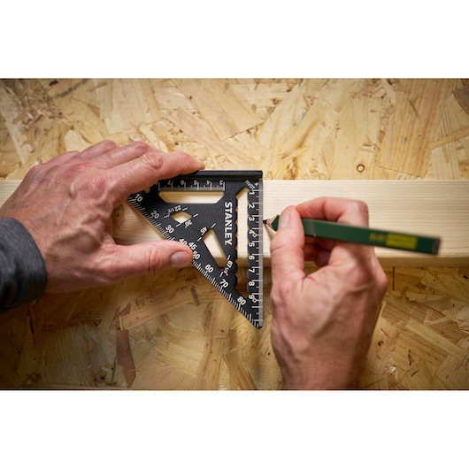 Stanley STHT46100-0 black triangular square used to mark wood, close-up photo on plywood surface.