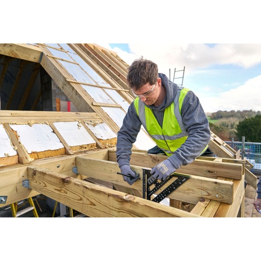 STANLEY STHT46102-0 roofing square used by a worker for wood measurement on construction site.