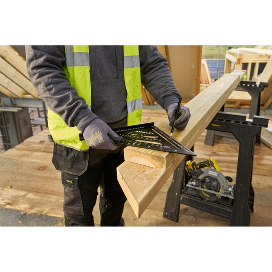 STANLEY STHT46102-0 rafter square in use marking wood, outdoor construction site, product demonstration.