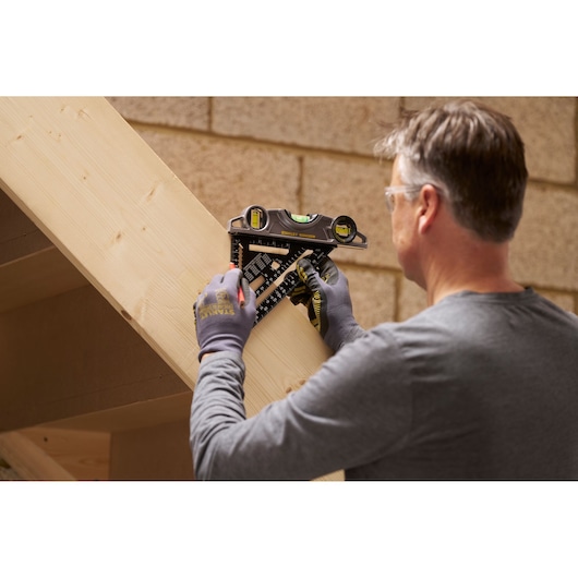 STANLEY STHT46104-0 layout tool in use for marking an angled wooden beam, shown in workshop setting.