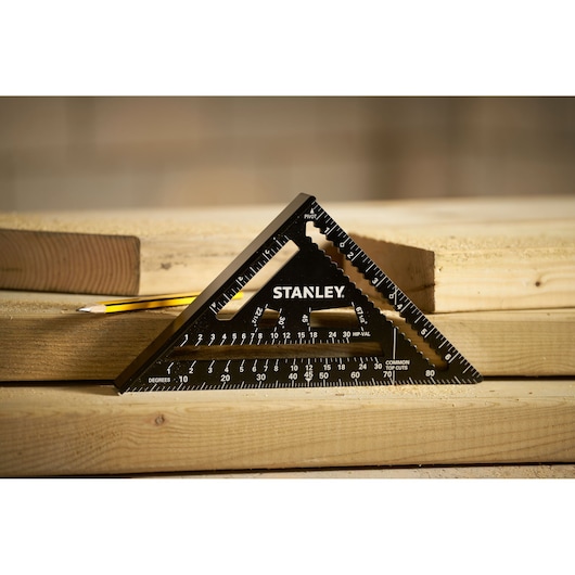 STANLEY STHT46104-0 black triangular carpenter's square on lumber, side angle, woodworking setting.