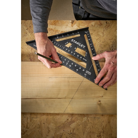 Photo of STANLEY STHT46105-0 black plastic rafter square used to mark wood on a workbench.