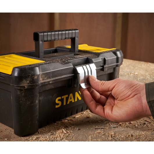 Photo of STANLEY STST1-75515 toolbox with yellow lid and metal latch being opened on workbench.