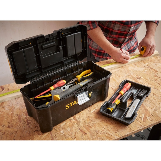 STANLEY STST1-75518-KR black toolbox open with assorted tools, tray beside, shown on workbench.